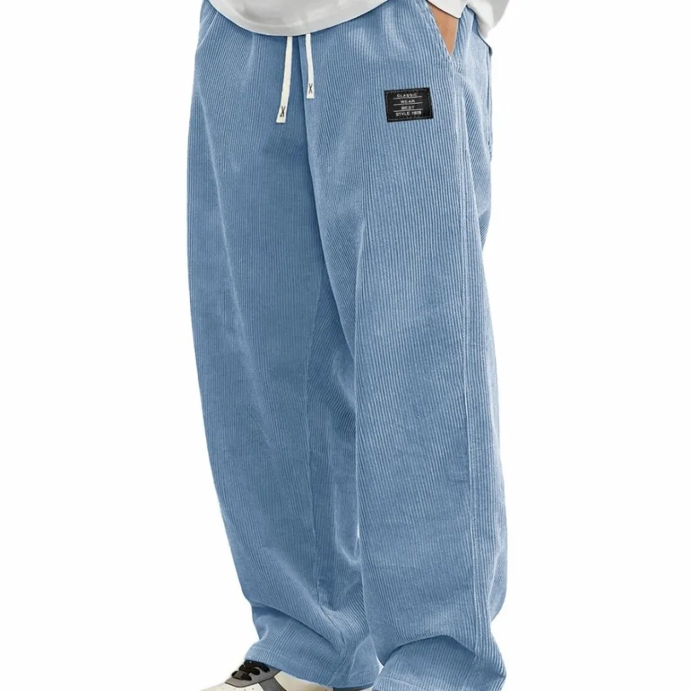 Novas calças compridas confortáveis de outono masculinas europeias, calças casuais de tecido de veludo com logotipo solto