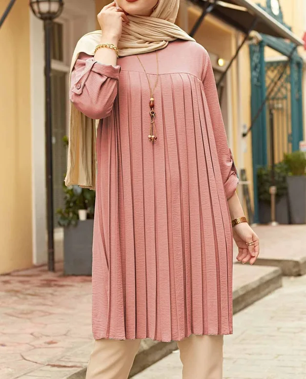 Dusty pink pleated tunic with button-tab sleeves styled with beige trousers
