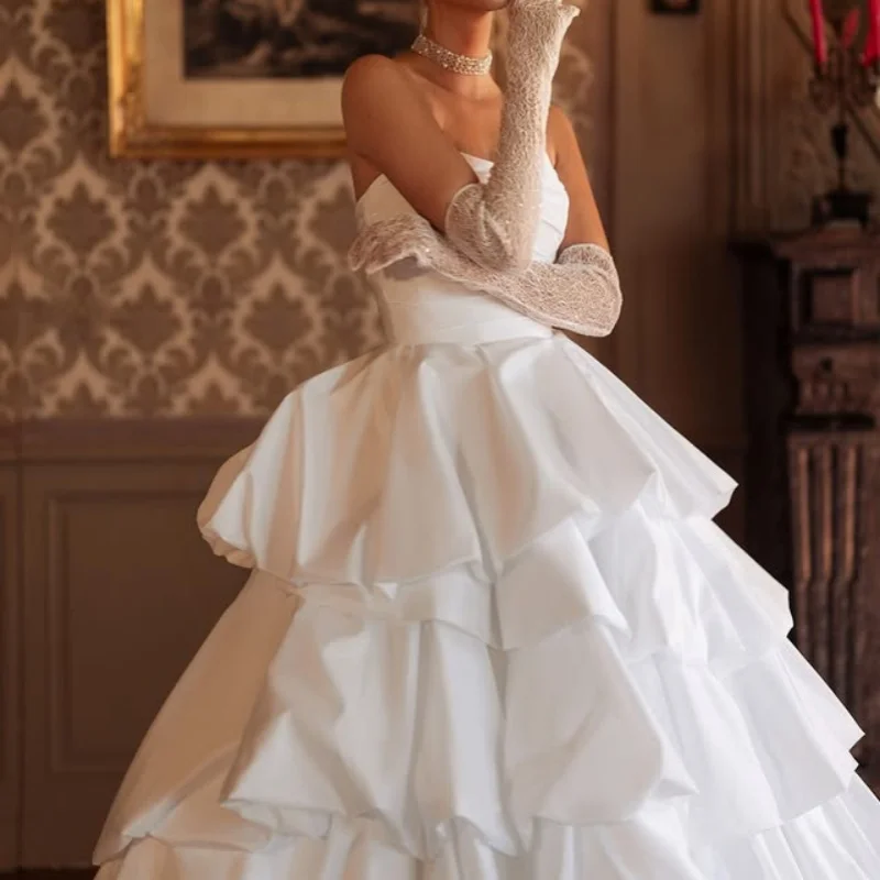 Abiti da sposa con applicazioni in raso bianco di abiti da sposa con decalcomania a strati senza maniche con spalle scoperte realizzati su misura