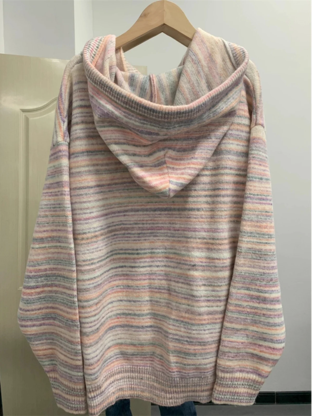 Elegancki sweter z kapturem, dzianinowy, damski, jesienno-zimowy, luźny krój, kolorowy, w paski, płaszcz, sofistyczny styl.