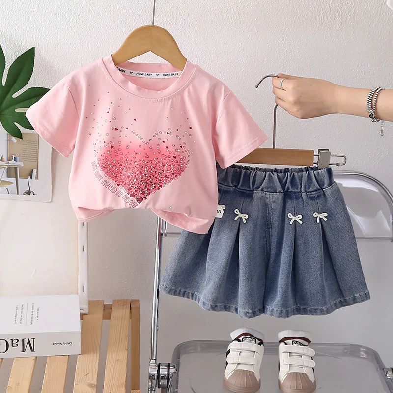 

Летний комплект для девочек 2026: Новая милая футболка с круглым вырезом, стразами и коротким рукавом, а также плиссированная юбка с бантом (комплект из двух предметов)