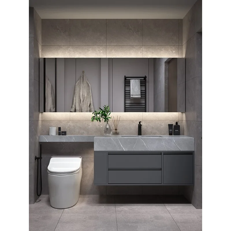 

Комплект мебели для ванной комнаты: тумба с интегрированной раковиной из каменной плиты, удлинитель для унитаза, современный минималистичный умывальник.