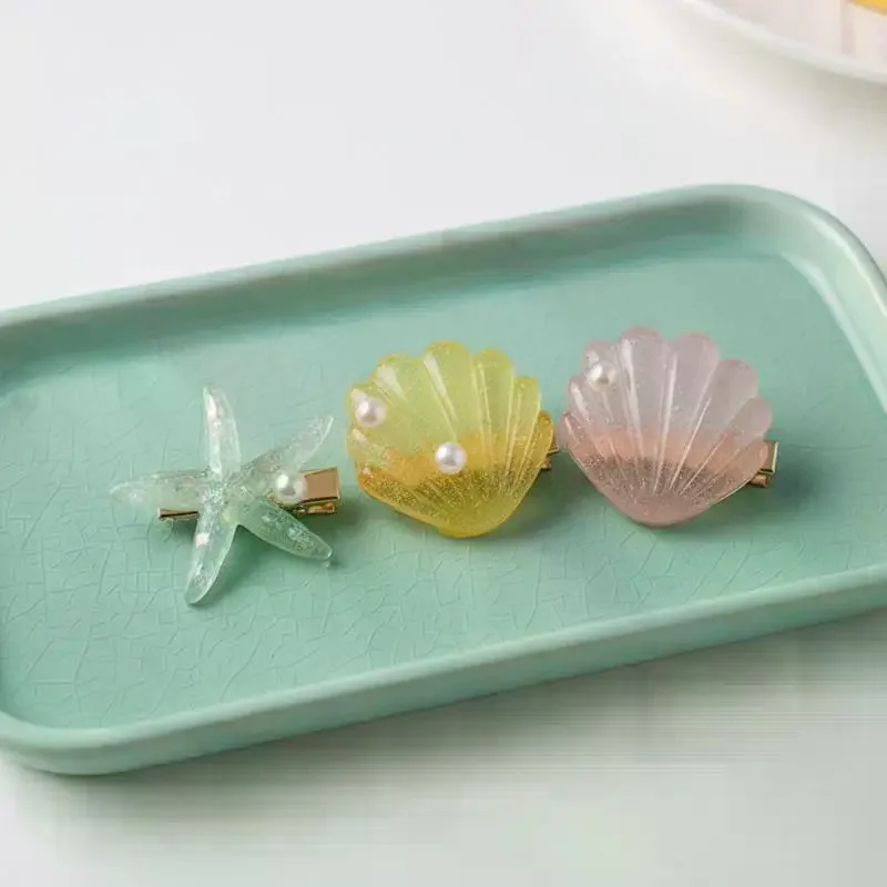 2 pinces à cheveux élégantes en forme d'étoile de mer et de coquillage, pinces à bec de canard mignonnes pour femmes, accessoires pour cheveux pour l'été, la plage, les vacances et les fêtes