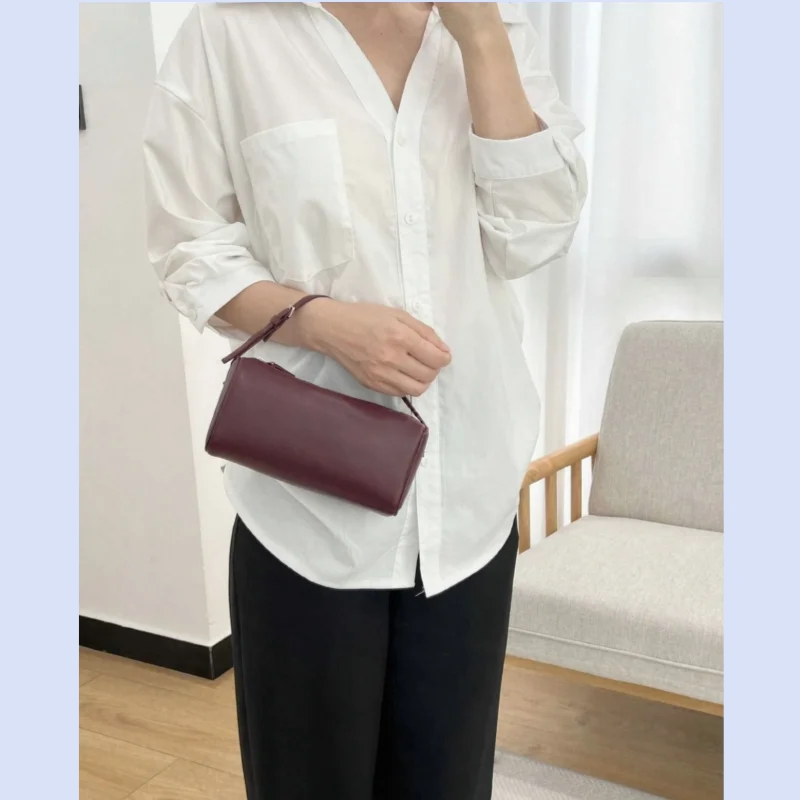 Women's minimalist style cowhide single shoulder messenger bag with soft and supple handle and underarm pencil holder