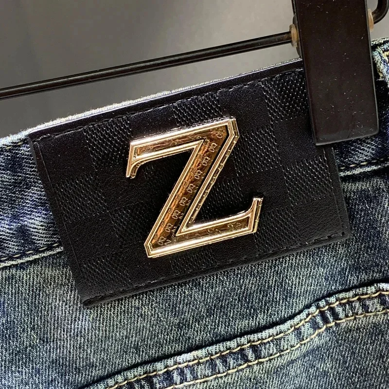 Primavera e outono 2026 nova marca na moda emenda remendo retro jeans calças masculinas fino ajuste pés pequenos rascal bonito denim