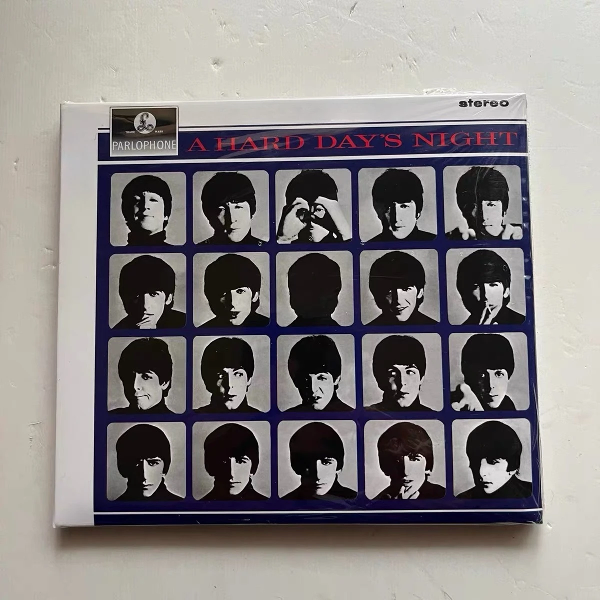 A Hard Day's Night, CD de Rock Británico, Portada con Retrato en Blanco y Negro sobre Fondo Azul, Edición Coleccionable Premium