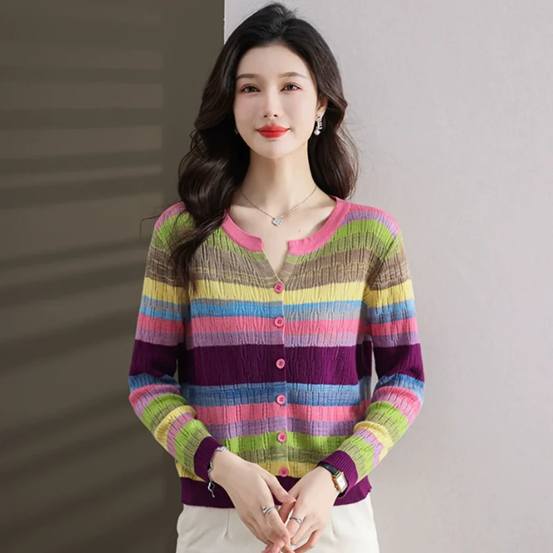 가을 신상 여성복 디자인은 속이 빈 V넥과 레인보우 컬러 패치워크 스트라이프가 돋보이는 긴팔 스웨터입니다.