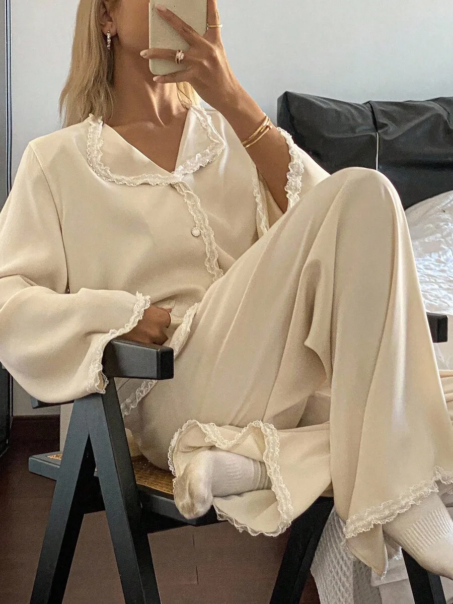 

Кремовый атласный пижамный комплект с кружевной отделкой, топом с V-образным вырезом и длинными рукавами, а также широкими брюками.