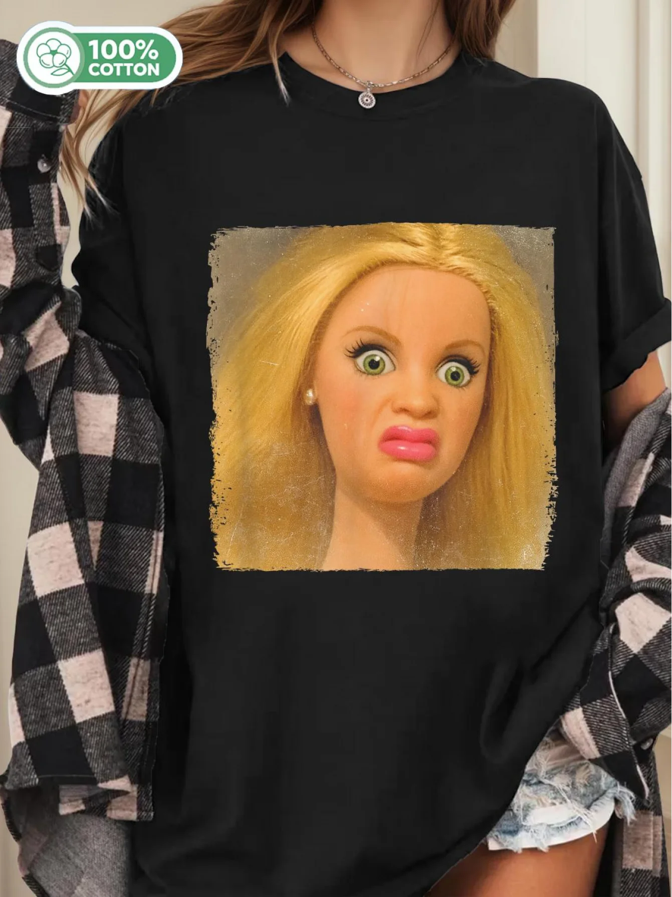 Camiseta de meme con cara de muñeca aterradora, de corte holgado, con estampado de ojos y boca expresivos y espeluznantes, ideal para amantes de los memes y fiestas de cultura pop.