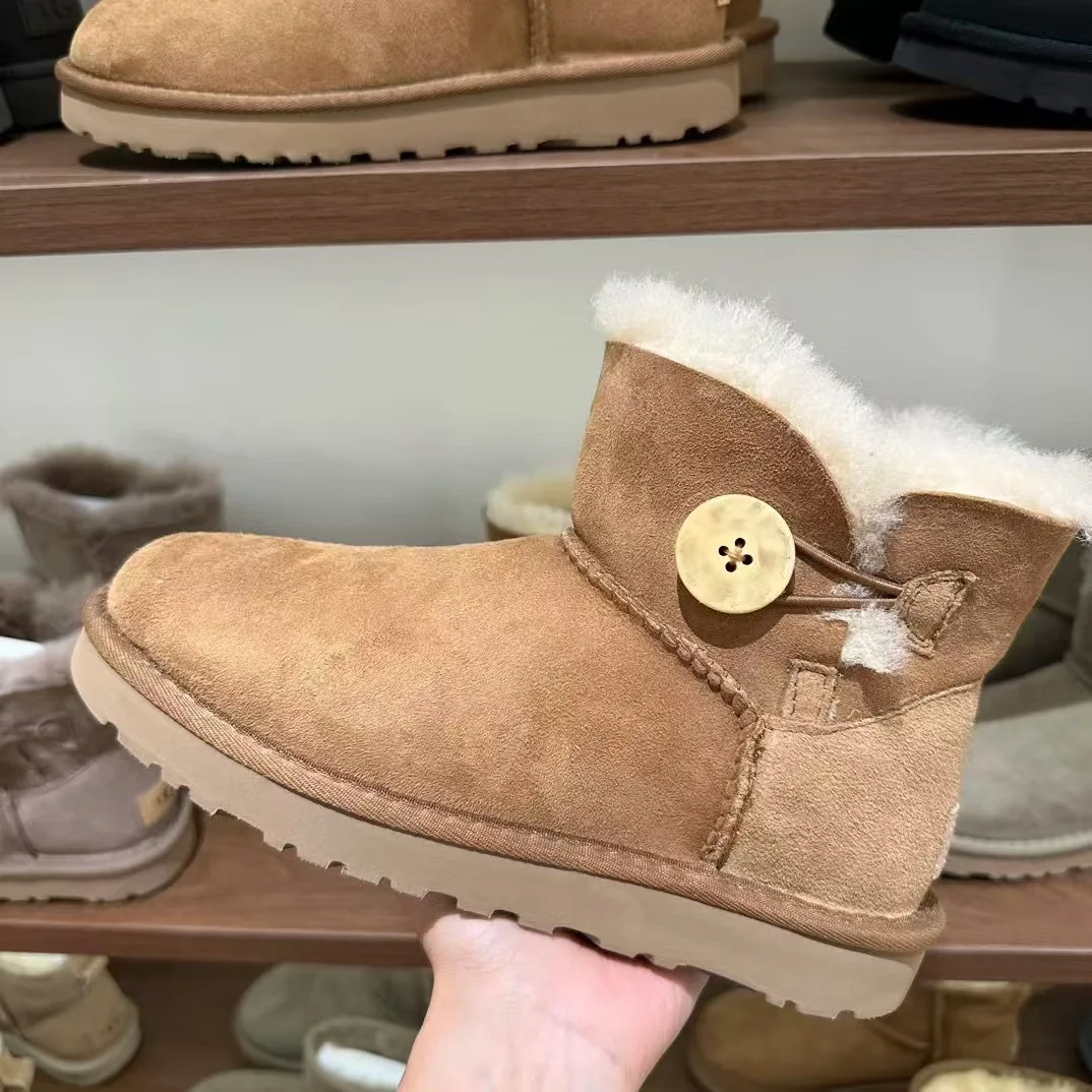 Nuevas botas de nieve de corte bajo de piel de oveja de invierno integradas para mujer impermeables estilo de botón de lana real cálido y cómodo fondo plano