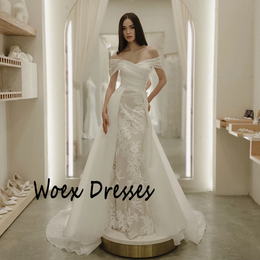 Suknia ślubna z organzy w kolorze białym, z odkrytymi ramionami, aplikacjami, trenem Watteau, odkryte plecy, fason A-line, długość do podłogi.