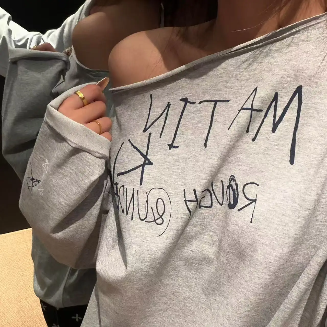 MATIN KIM Graffiti‑Letter Print Long‑Sleeve T‑Shirt, Loose Asymmetrical One‑Shoulder Top Korean Streetwear for Spring Autumn