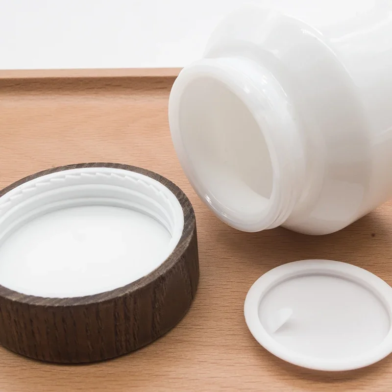 

Cosmetic porcelain white glass jars with bamboo lid kin care refillable recycled luxury opal face cream glass jars darkwoodenlid