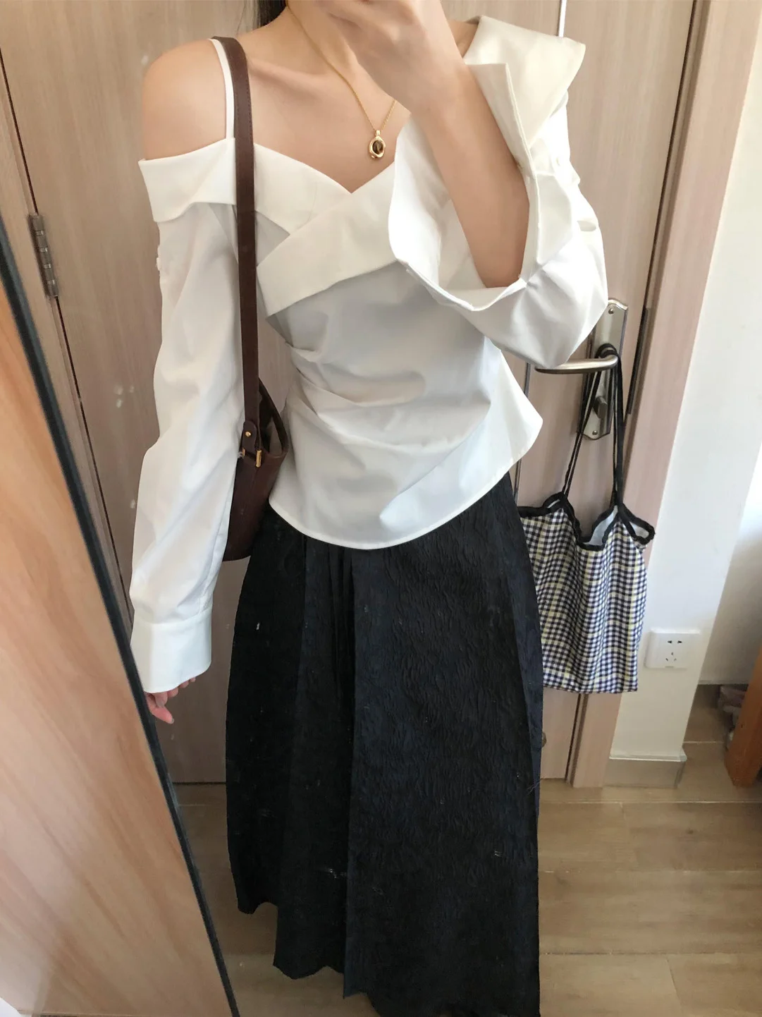 

Модный весенний комплект для женщин: белый топ с длинными рукавами и открытыми плечами, юбка с высокой талией, стильный образ для работы и повседневной носки.