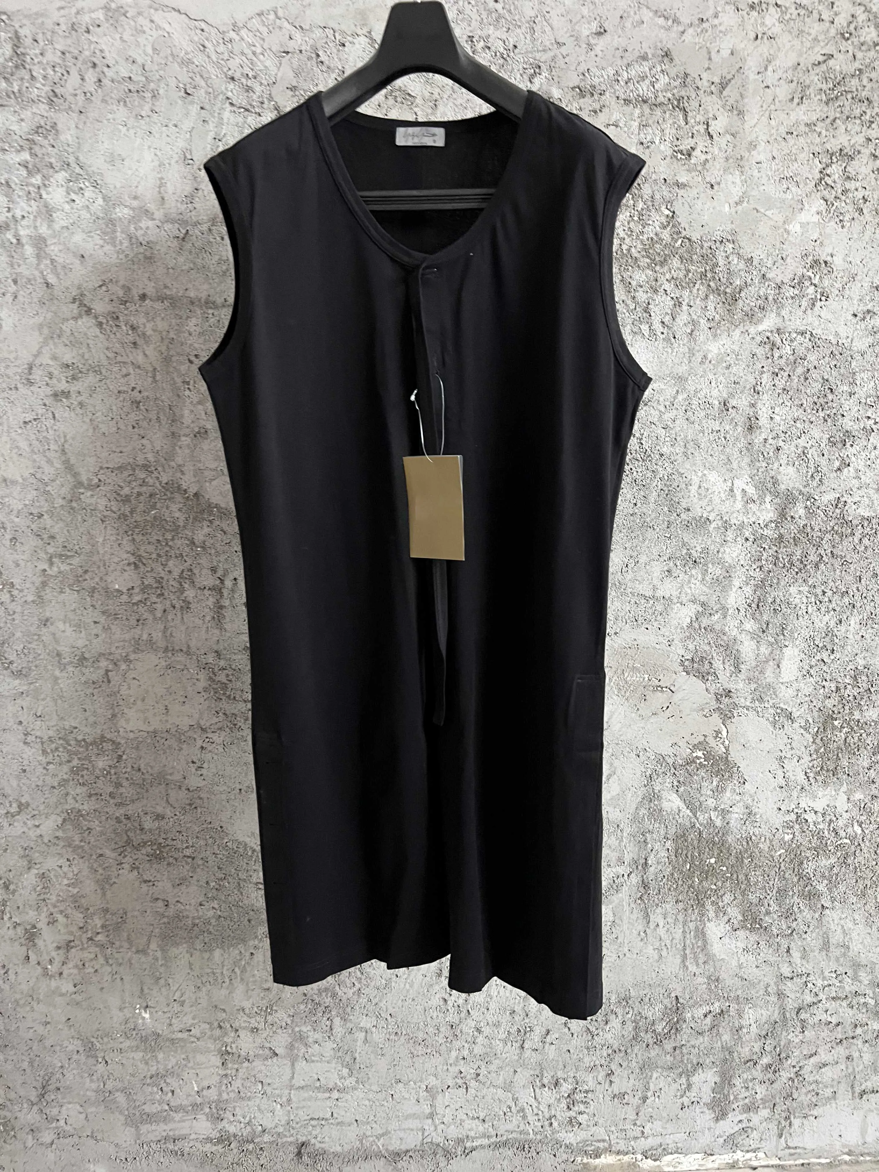 A black top for men with a round neck, a sleeveless long vest decorated with buttons and a pure cotton design