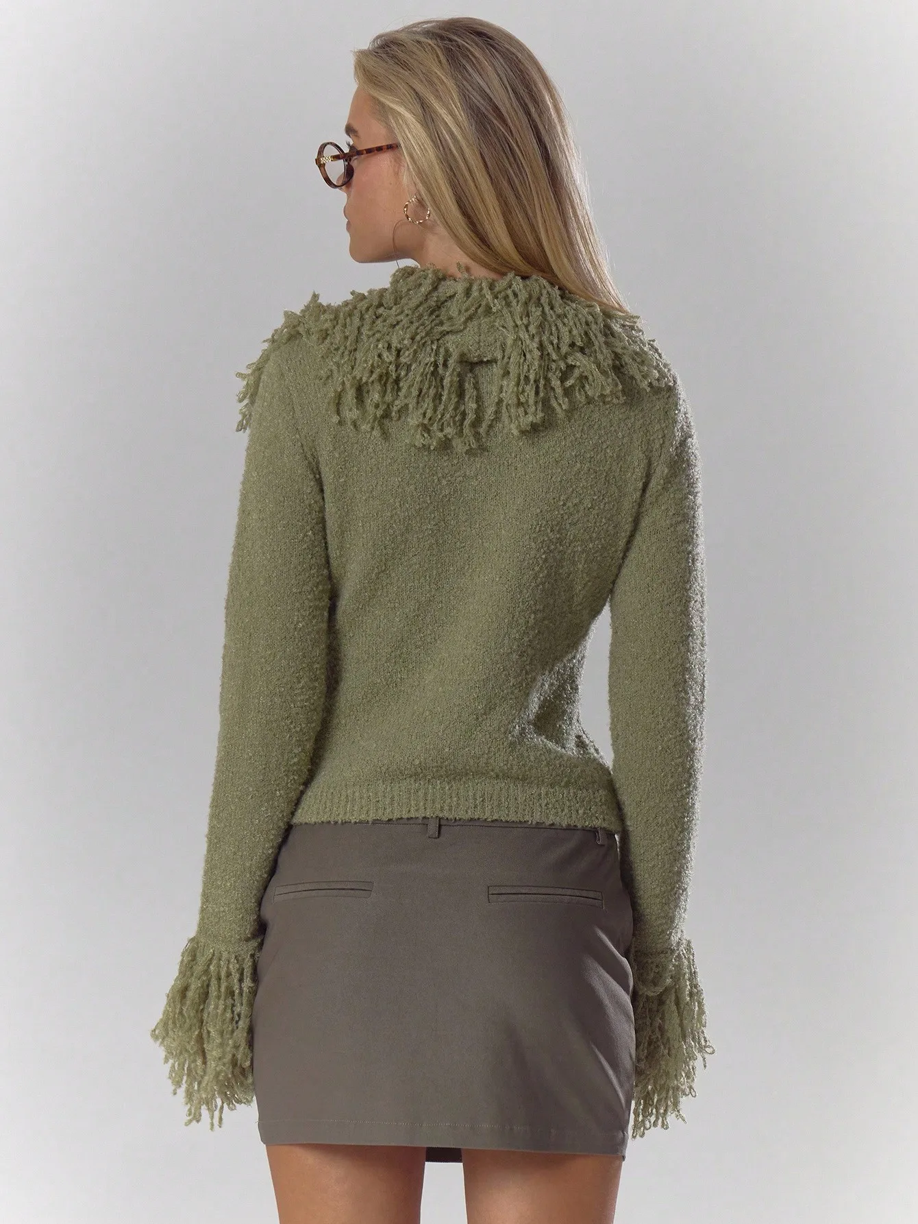 Kardigan w kolorze oliwkowej zieleni z puszystym wykończeniem i rękawami z frędzlami, idealny na jesień i zimę, zapewniający elegancję na co dzień.