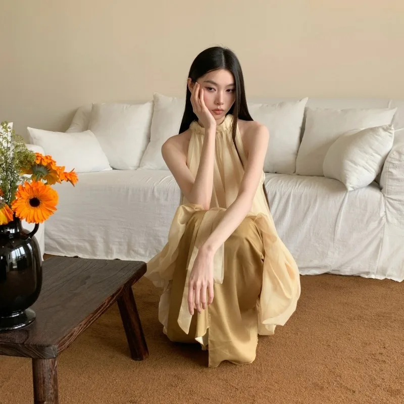 Sukienka damska letnia, minimalistyczna, długa, bez rękawów, z dekoltem typu halter, w stylu retro, z satynowymi wstawkami, odkrywająca ramiona.