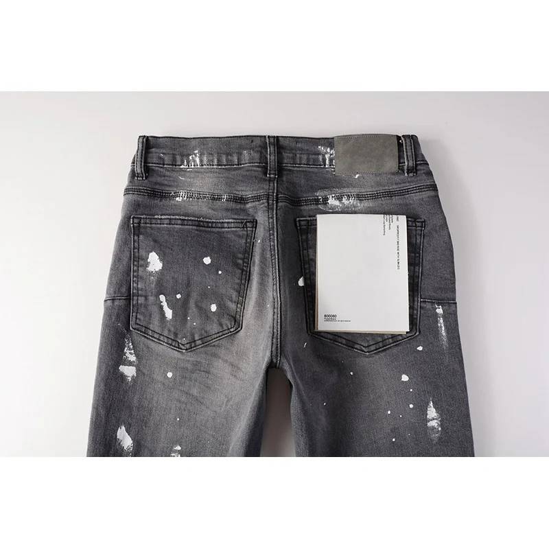 جينز رجالي من American High Street Fashion ذو ثقوب تالفة باللون الرمادي المتعثر على الجدران، جينز ممزق بأزرار قابلة للتمدد