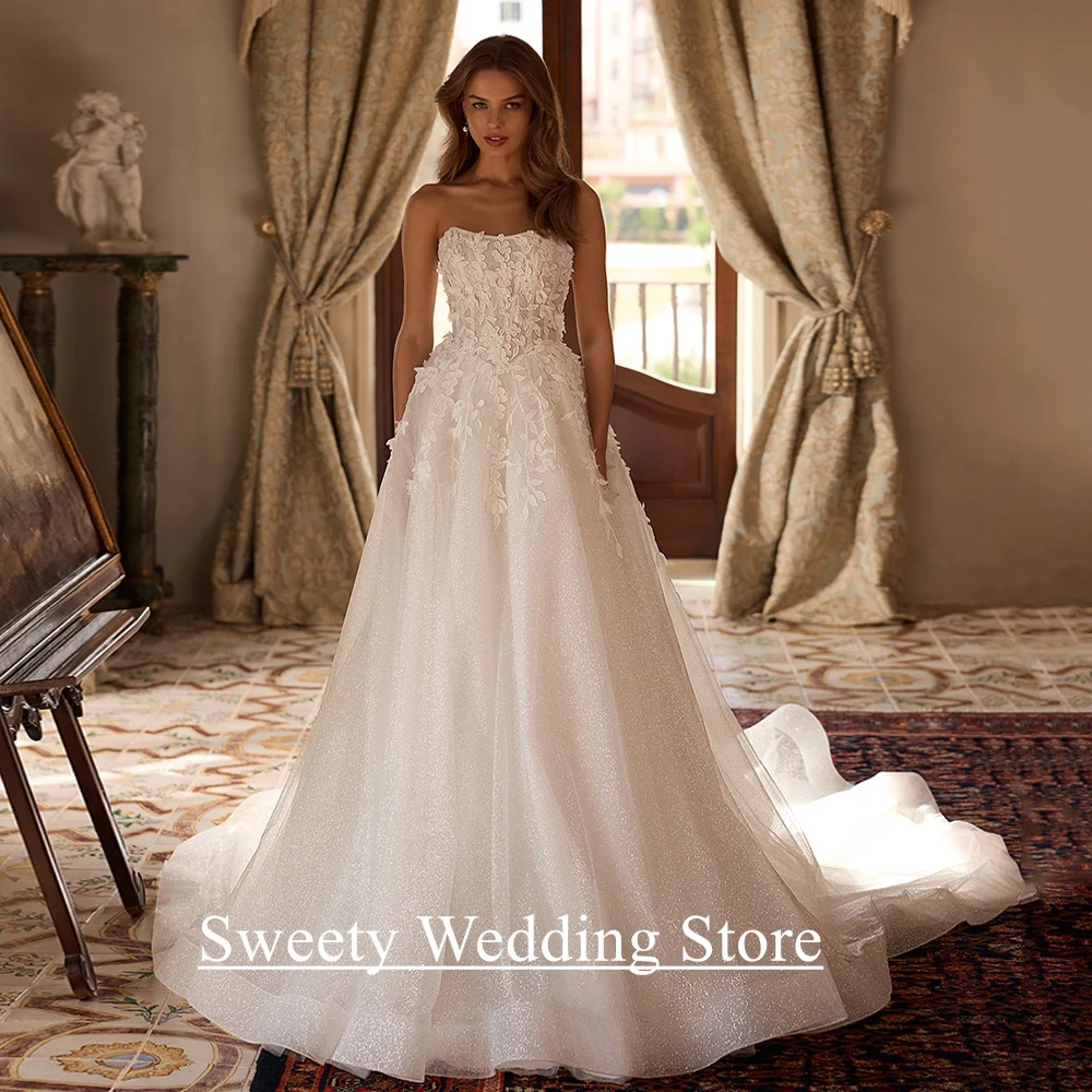 Glänzendes Hochzeitskleid, maßgeschneidert, trägerlos, ärmellos, durchsichtig, Applikation, Glitzer, Tüll, A-Linie, Saudi-Brautkleid für die Braut