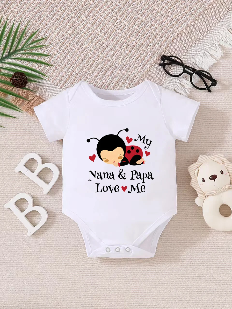 Playful letter-printed baby short-sleeve triangle bodysuit. Button closure for easy dressing, machine washable