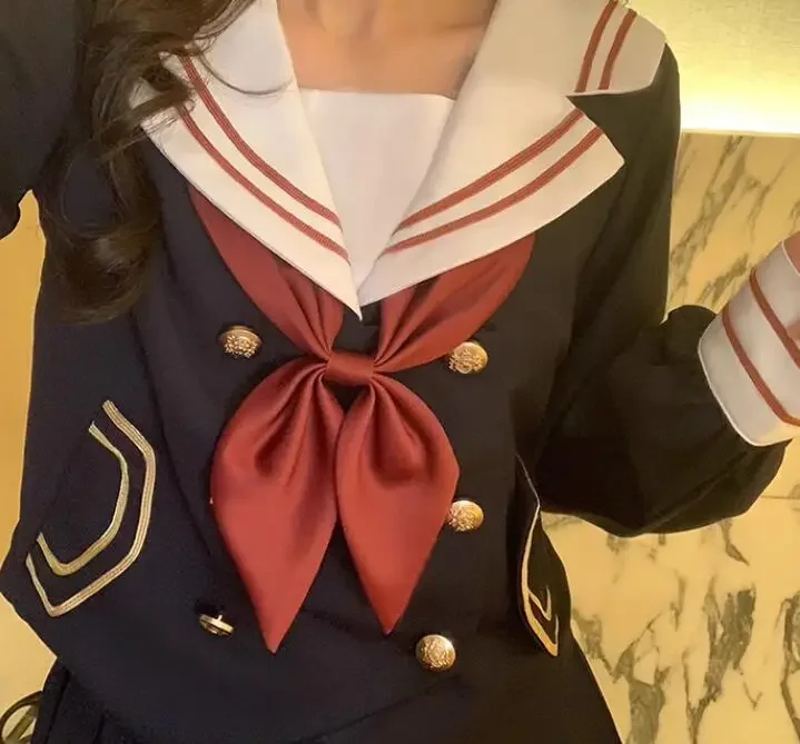 Le ragazze dell'uniforme scolastica giapponese vestono il vestito da marinaio primaverile