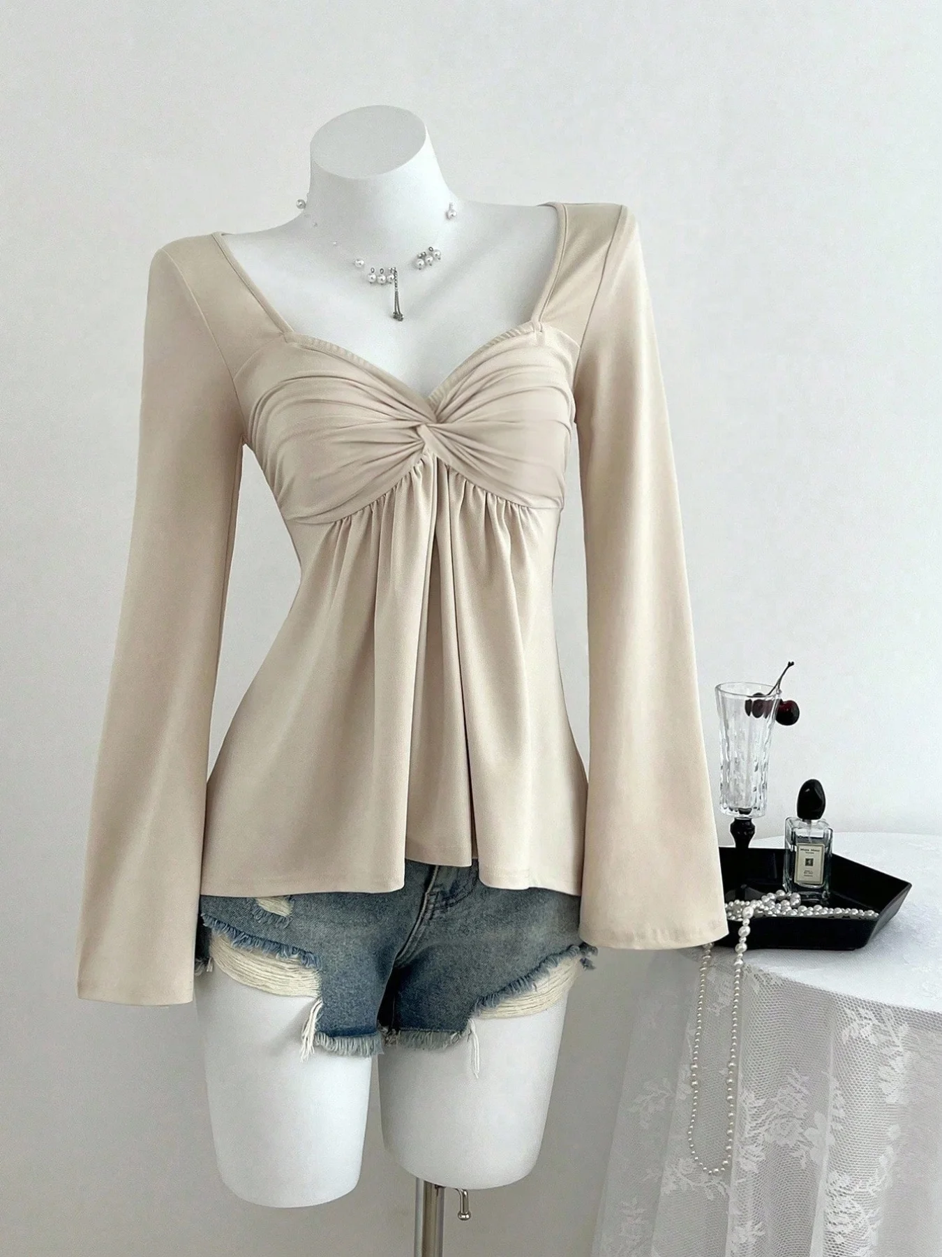 Sens du design français d'automne et d'hiver, tempérament de mode torsadé sur la poitrine, haut pull à manches longues pour femmes