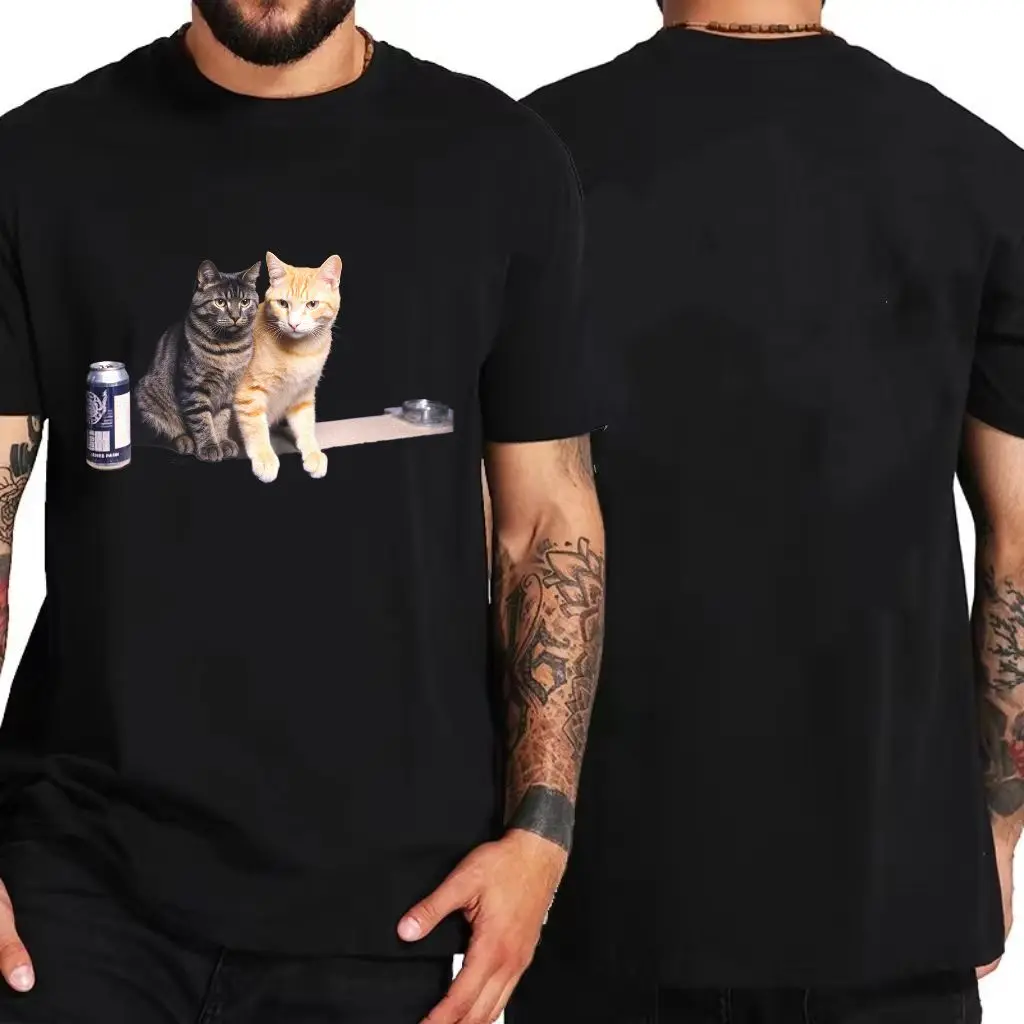 تي شيرت أبيض بتصميم مطبوع لقطط تابي باللون الرمادي الداكن والبرتقالي الفاتح جنبًا إلى جنب، علبة مشروبات داكنة على اليسار، موزع شريط #2