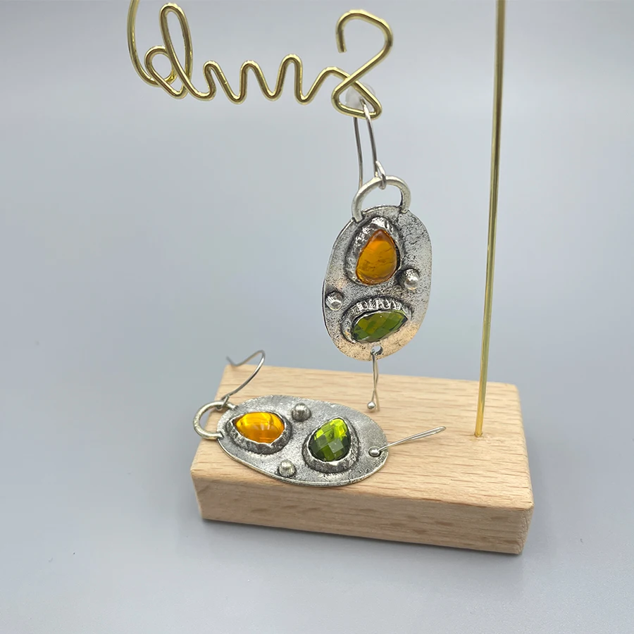 A pair of vintage bohemian oval earrings, green and yellow stone inlays, distressed party decorations, cocktail receptions