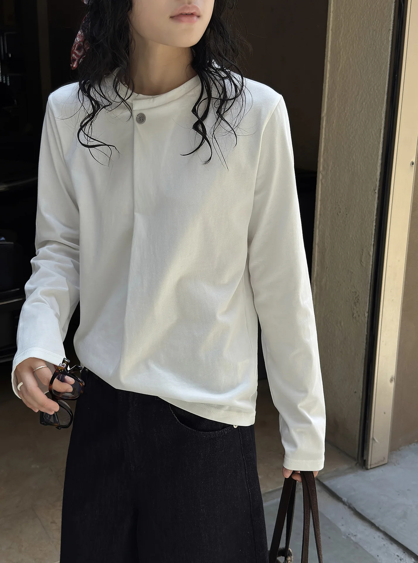 Nuovo senso del design francese di inizio autunno, T-shirt a maniche lunghe con abbottonatura obliqua a un bottone, top con silhouette ampia per le donne