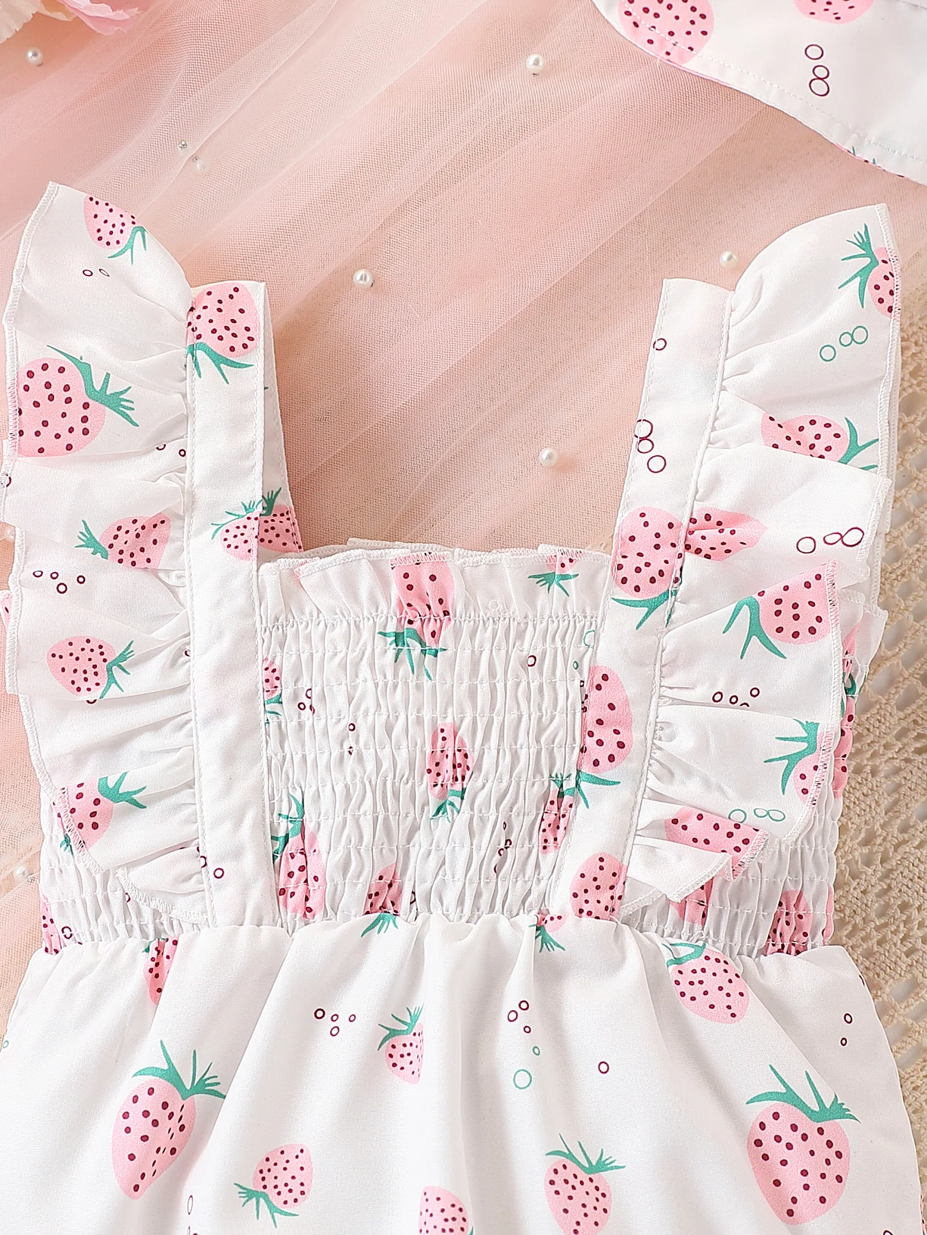 فتاة لطيفة في رومبير كاجوال بنمط الفراولة بالكامل، بما في ذلك ملحق القبعة، للصيف.