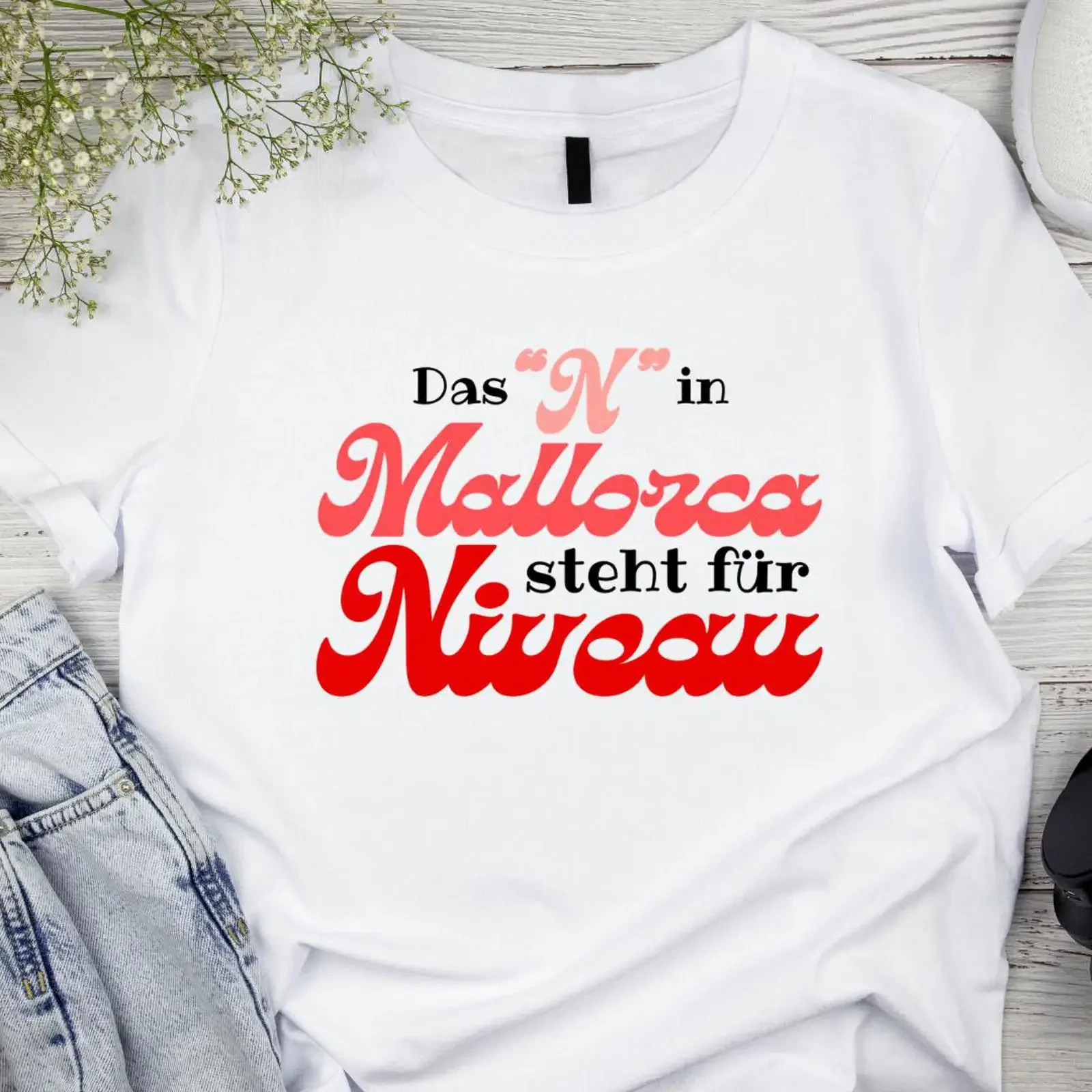 May include White t shirt with a red and pink graphic that says Das N in Mallorca steht für Niveau vintage Washed Stylish