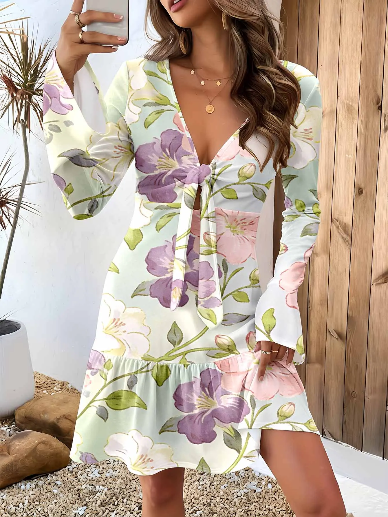 Deep V-neck long-sleeved waist-cinched short skirt, with intricate cut-out detailing to create a romantic vibe