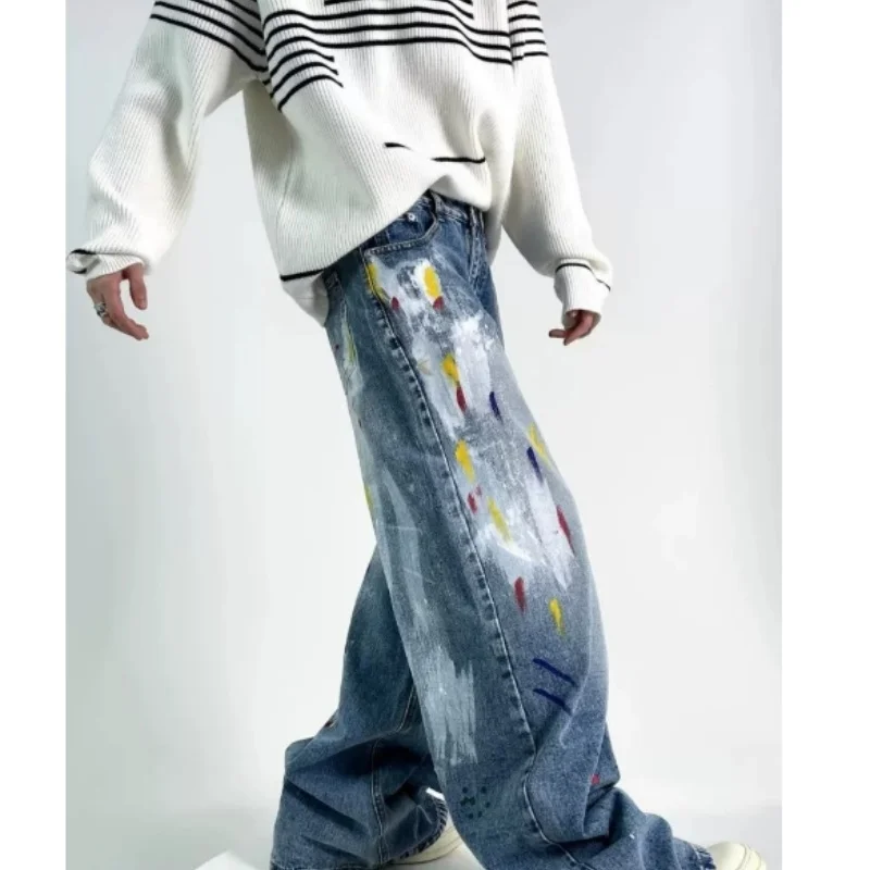 Calças jeans de perna larga estilo hip-hop com estampa de grafite e tinta, inspiradas nas ruas europeias e americanas.
