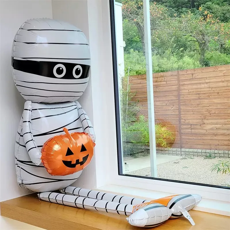 مومياء تحمل بالون من رقائق الألومنيوم اليقطين باللون الأبيض والبرتقالي لعناصر رعب لتزيين حفلات الهالوين