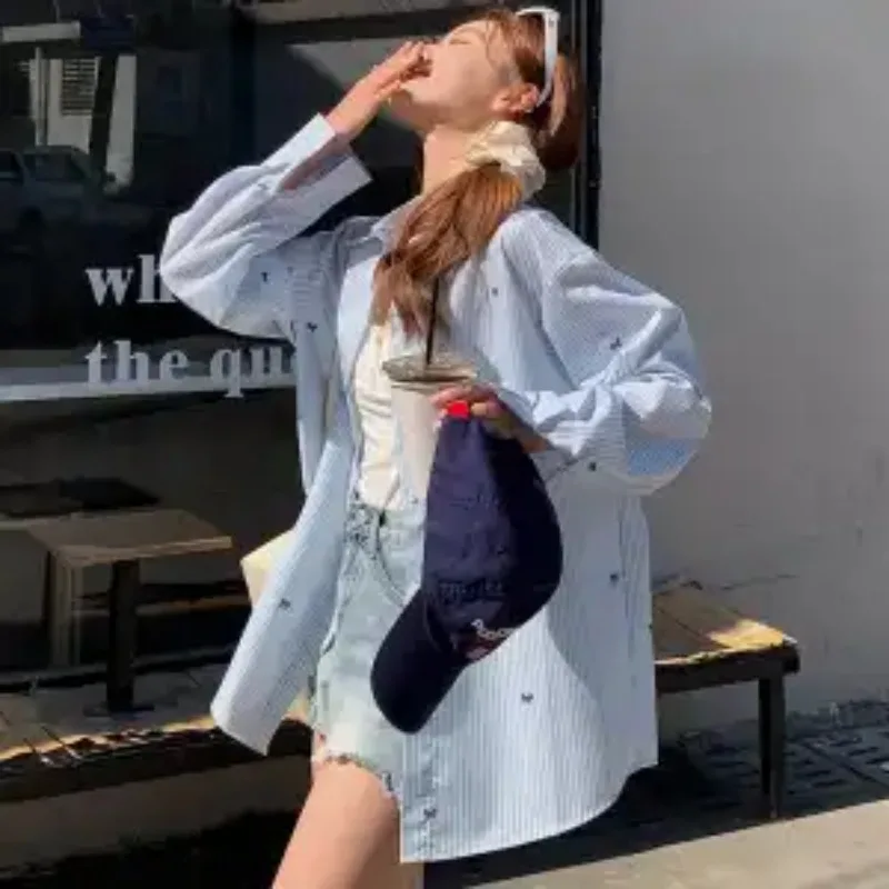 เสื้อเชิ้ตลายทางสีฟ้า เสื้อเชิ้ตแขนยาวพิมพ์ลายโบว์สไตล์เกาหลีลำลองสำหรับผู้หญิง