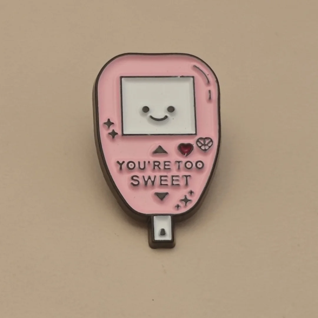 A unique and cute metal brooch in the style of a handheld gaming console, suitable for women to wear.