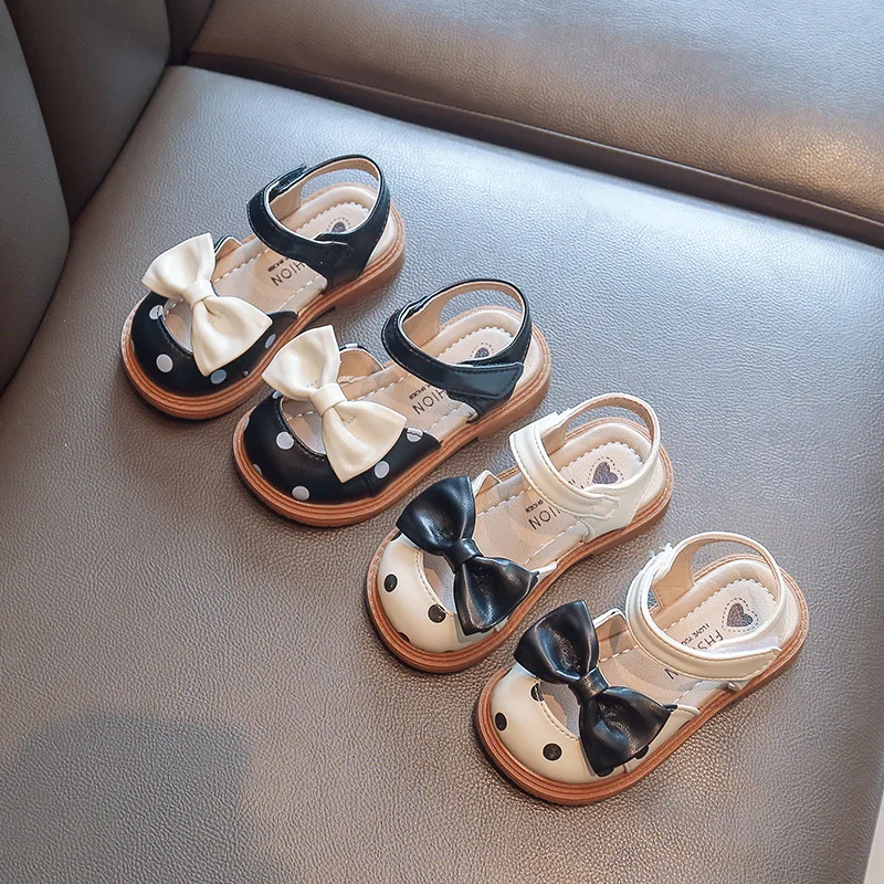 Sandalias de cuero para bebé y niña, zapatos de verano para niños pequeños con cubierta de dedo, sandalias de playa con puntos y pajarita de princesa