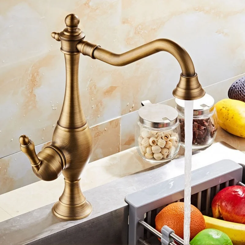 Antique-style brass kitchen sink faucet with rotating hot and cold water taps on the countertop