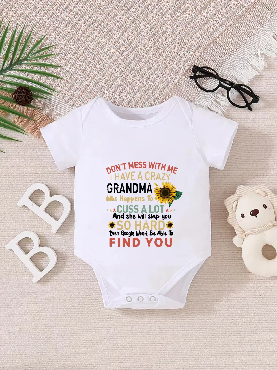 Playful letter-printed baby short-sleeve triangle bodysuit. Button closure for easy dressing, machine washable