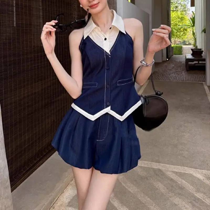 

Женский комплект из двух предметов: темно-синий джинсовый жилет без рукавов и плиссированные шорты с контрастной отделкой