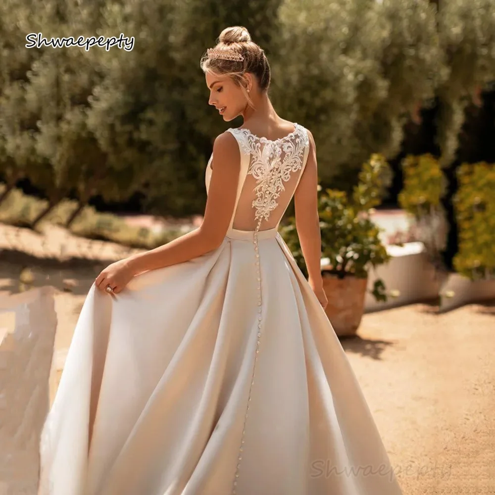 Prosta satynowa suknia ślubna w kształcie litery A z kieszeniami, bez rękawów, z krótkim trenem, długa, w kolorze kości słoniowej, z iluzorycznym tyłem, szyta na miarę.