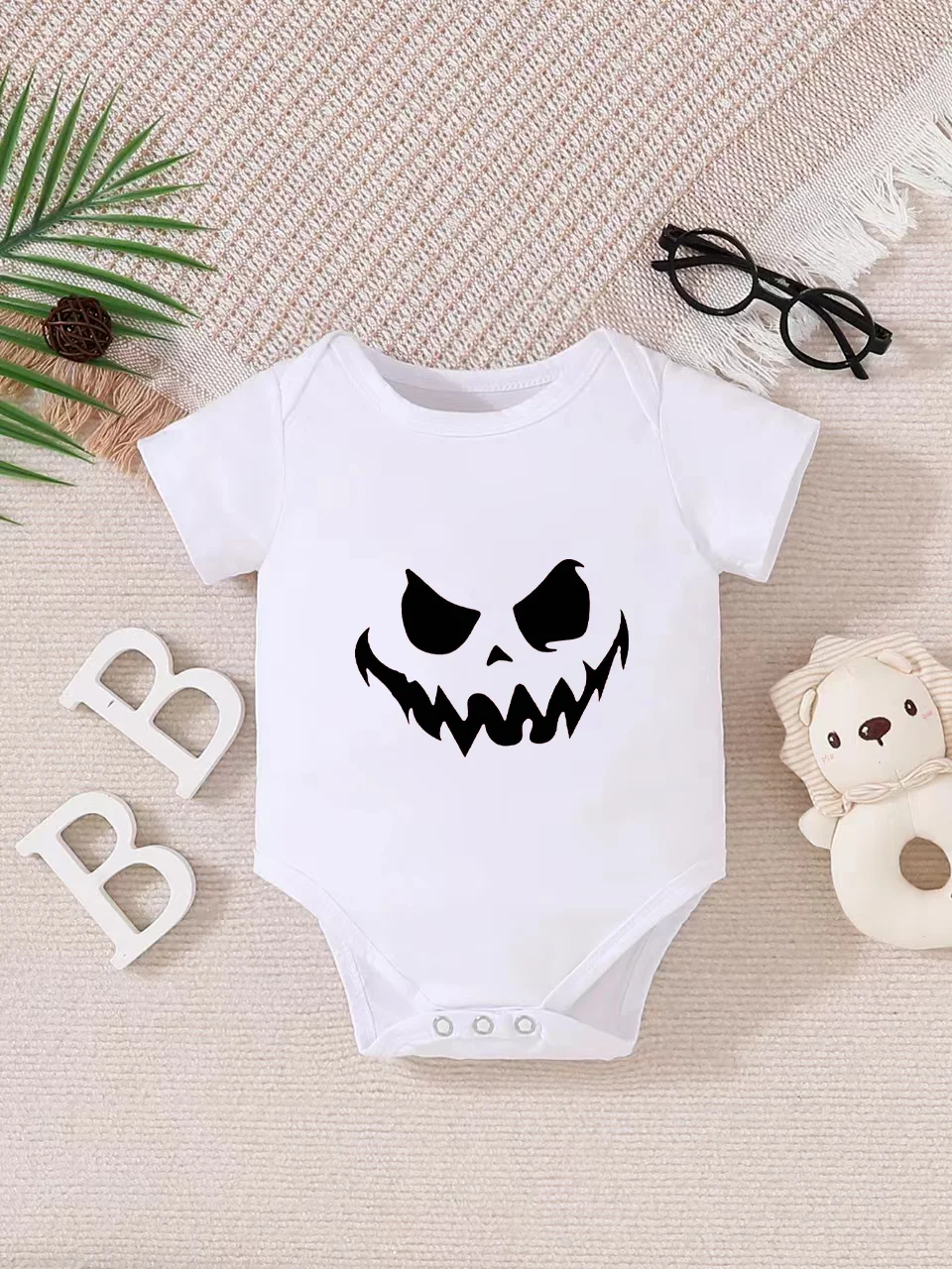 Playful letter-printed baby short-sleeve triangle bodysuit. Button closure for easy dressing, machine washable