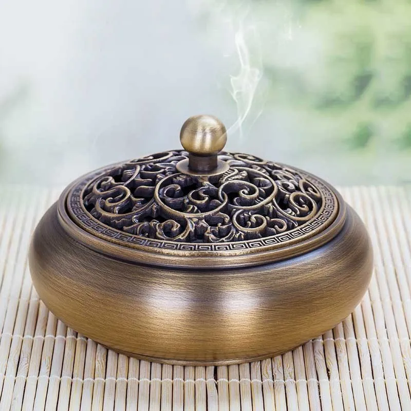 Brushed copper with intricate patterns, a three-legged small incense burner, a Vajrayana Buddhist ornament, and a
