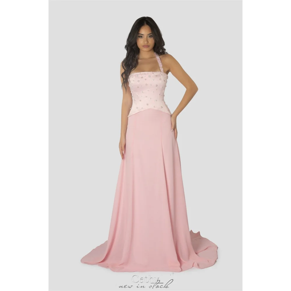 ชุดราตรีงานพรอมสีชมพูแบบคอ halter ประดับเพชร ดีไซน์ผูกเชือกด้านหลัง ทรงเอไลน์ แขนกุด ชายกระโปรงยาวแบบ sweep train ของ Cathy Customize