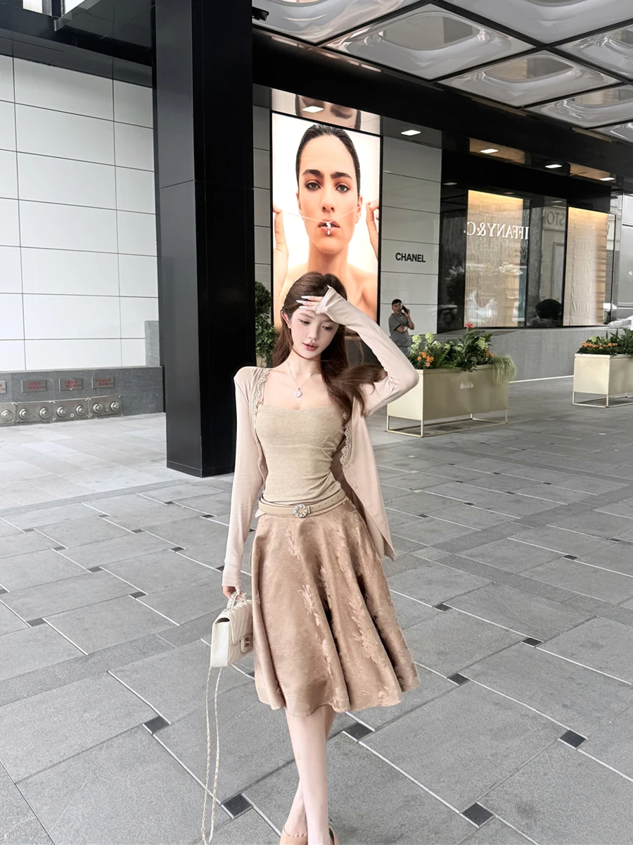 

Женский комплект из трех предметов: вязаный кардиган с кружевной отделкой и длинными рукавами, топ на бретельках и вышитая юбка. Весенний, премиум-класс.