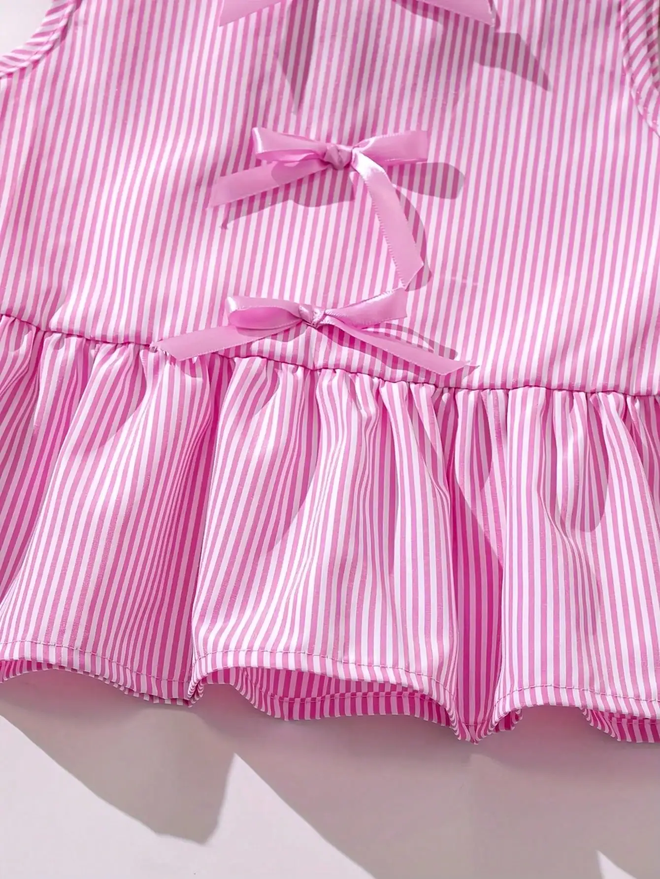 Modisches zweiteiliges Set für Mädchen: rosa-weiß gestreifter Rundhalspullover mit Schnürung, Schleife und Rüschenrand + rosa gestreifte Schmetterlings-Shorts. – Detail 11