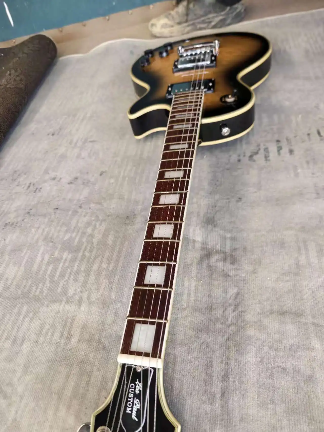 

Electric guitar made in China, with large floral veneer, black rimming, and black finish on the back.