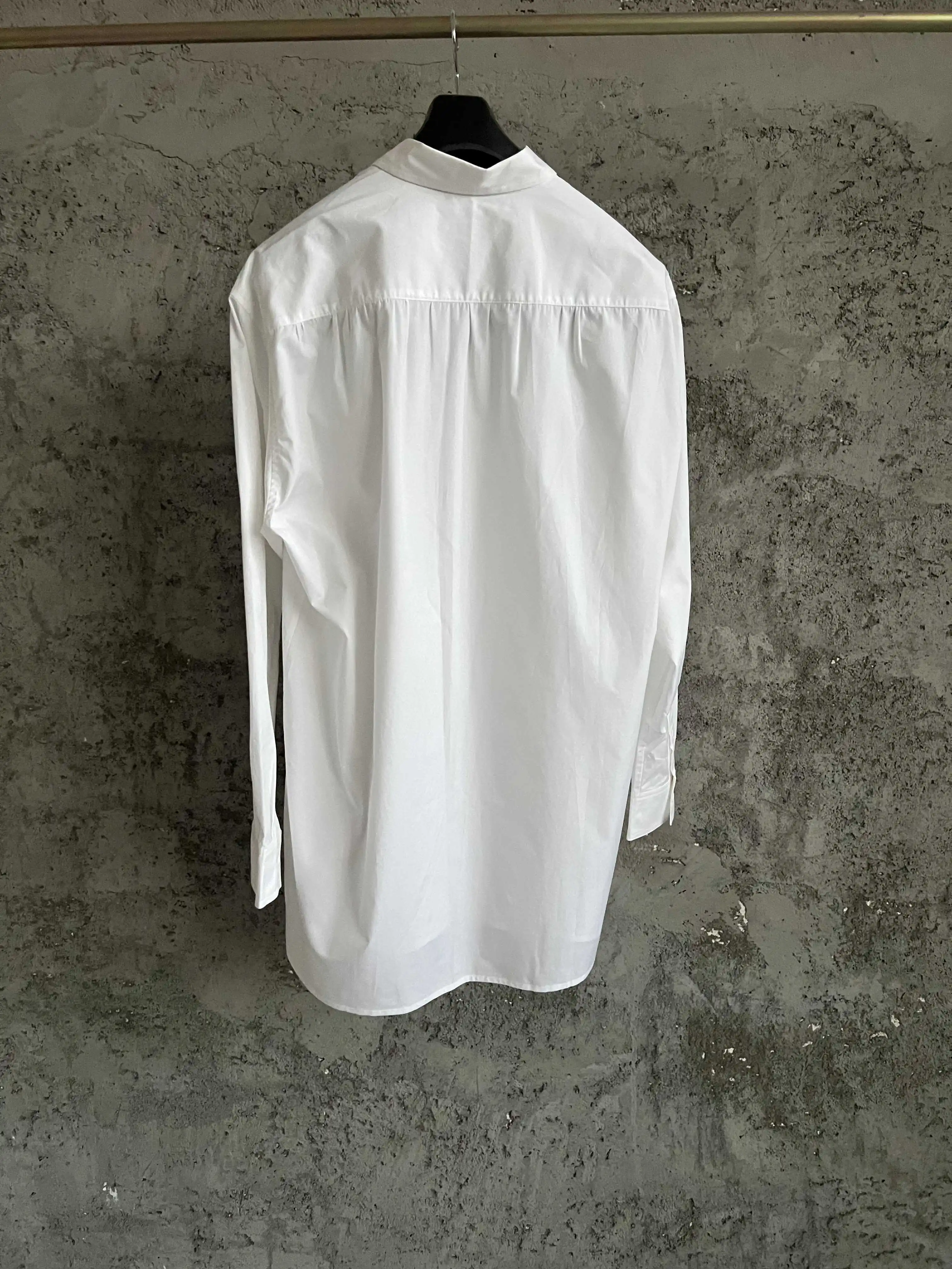 A mid-length shirt with a double-layer collar design, long sleeves, loose and irregular hem