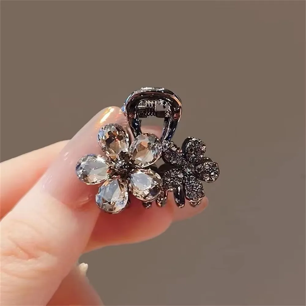 Pince à cheveux antique en alliage noir avec motif double grappe de fleurs en résine facettée gris fumé et détails micro-pavés