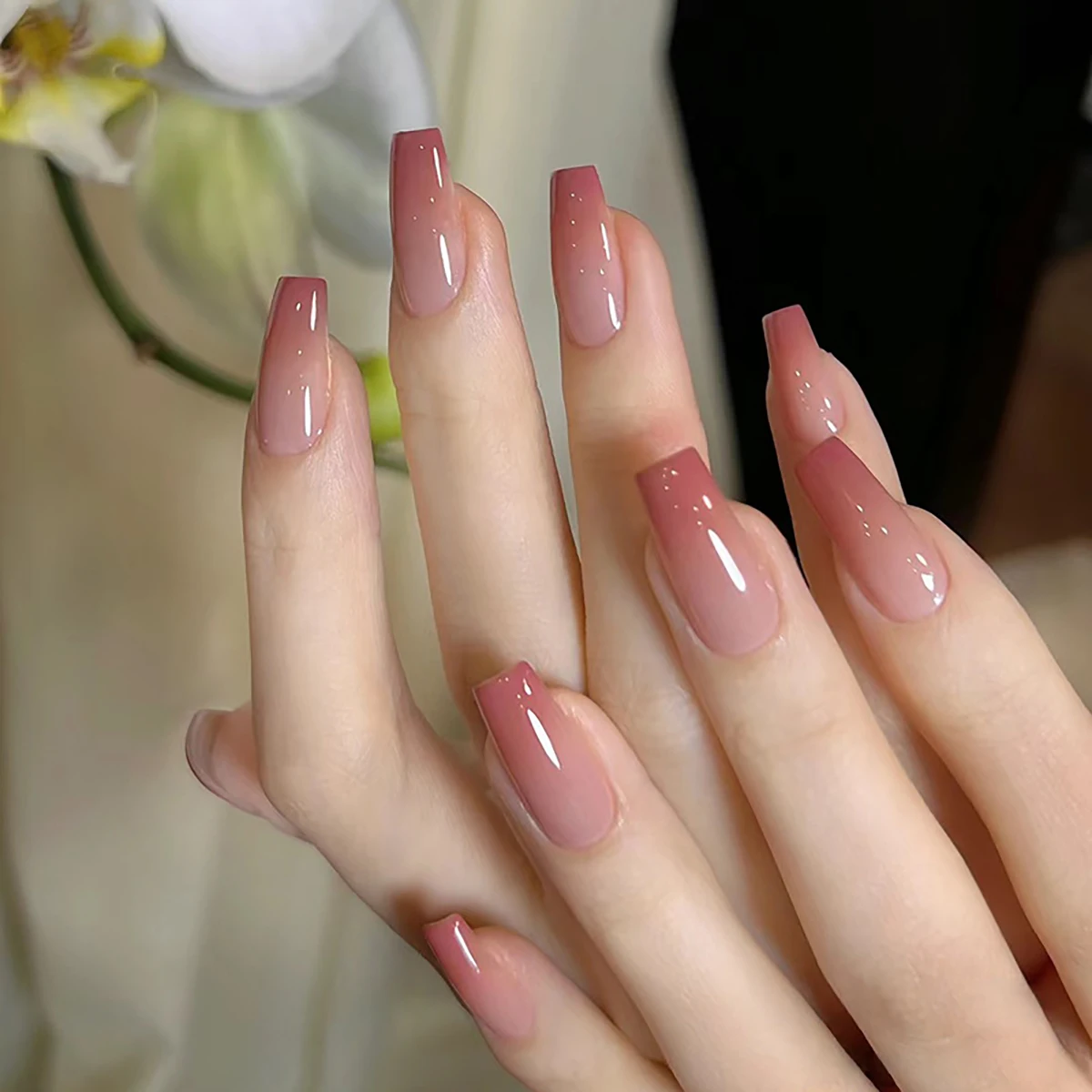 

A full set of 24 medium coffin-shaped fake nails with a peachy gradient design, including 1 jelly glue and 1 nail file, perfect